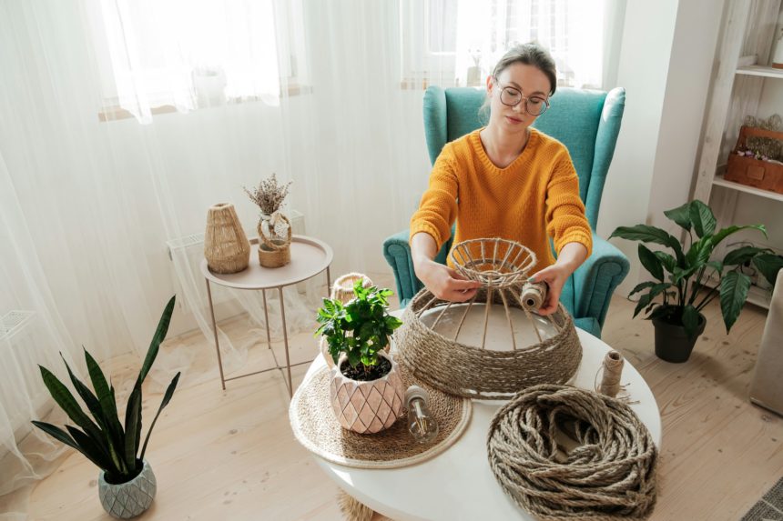 Woman makes handmade diy lamp from jute rope